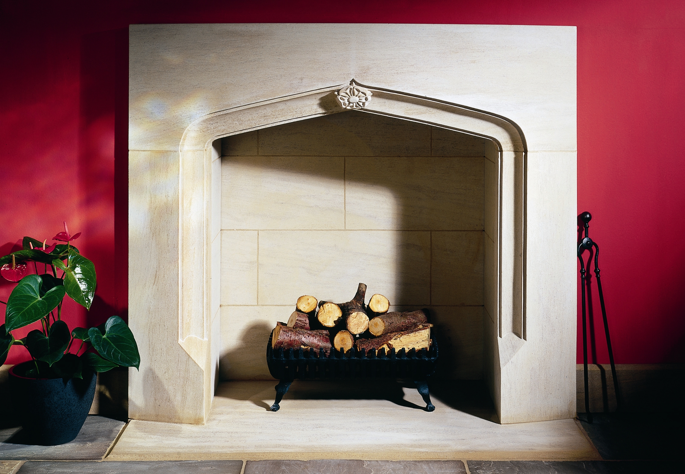 16. A modern interpretation of a Gothic fireplace in Ancaster Hard White stone, with carved rose detail – Derbyshire